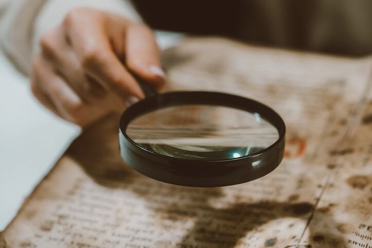 Historian scientist reading antique book with magnifying glass. Translation of religious literature. Manuscript with ancient writings. Treasures of the past. Museum piece.